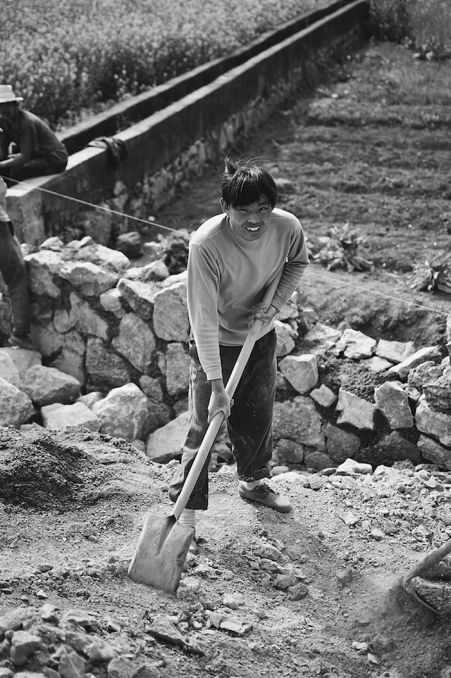 black and white photo of a man with a shovel